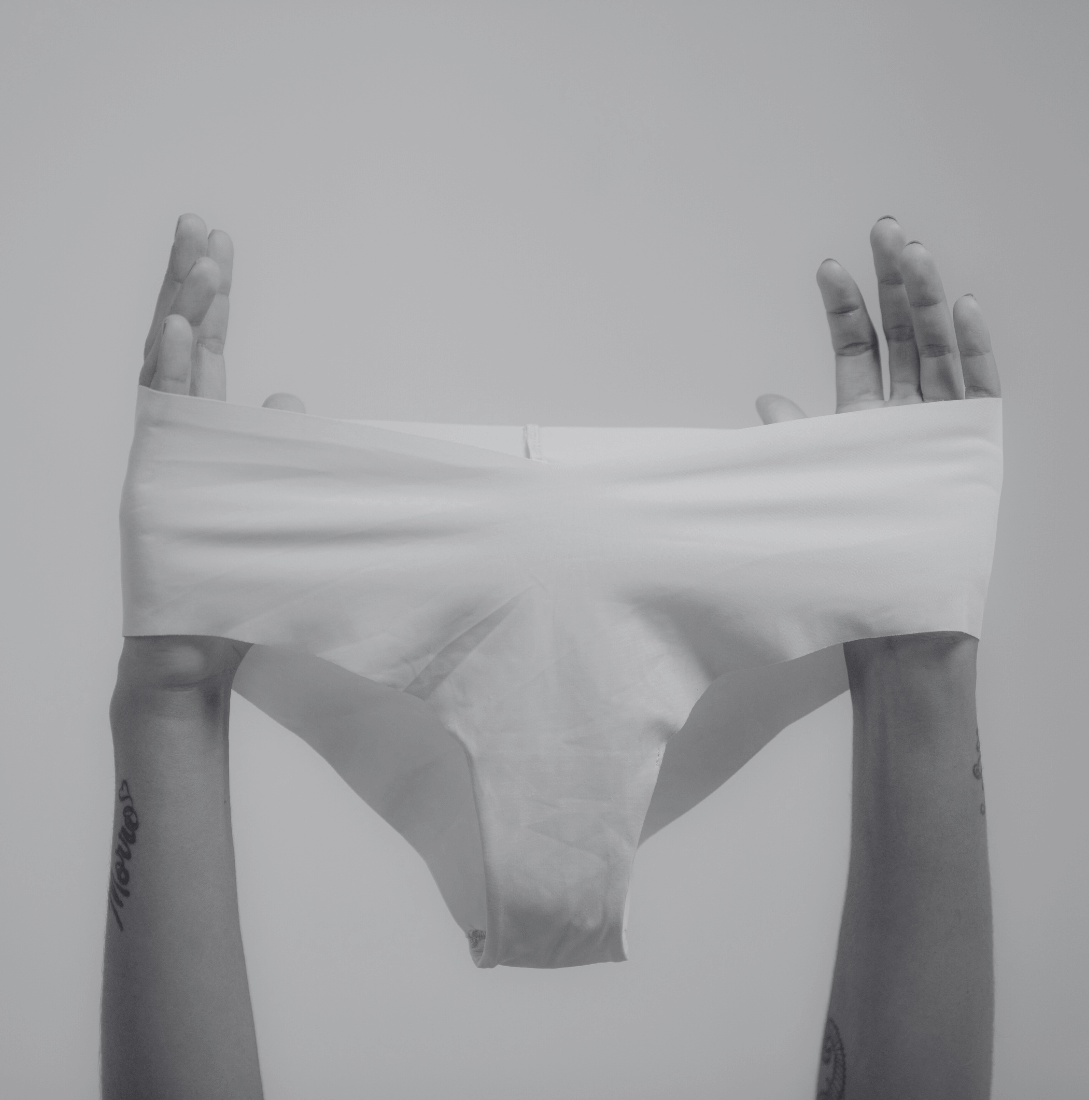 Woman holding up underwear checking for bacterial vaginosis